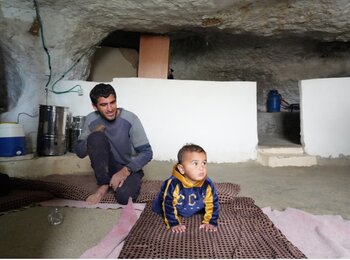 Mohammed and his baby at home. Photo: Ma'an