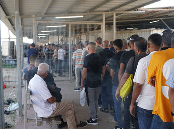 Palestinian workers from Gaza queuing at a checkpoint managed by Palestinian Authorities to cross to the Israeli-controlled Erez crossing before crossing to Israel for work. Source, OCHA oPt November 2022
