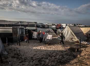 بدأ نحو 1.9 مليون شخص في غزة عام 2024 في حالة تهجير. صرّح مفوض الأمم المتحدة السامي لحقوق الإنسان بقوله «لا يمكننا التحدث عن السلامة في أي مكان. ينام الناس في الشوارع، في العراء.» مخيم مؤقت في رفح. تصوير برنامج الأغذية العالمي