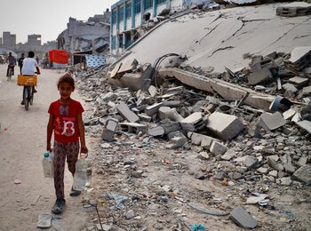 A young girl collects water in the Gaza Strip. Photo by UNRWA