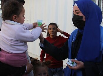 A humanitarian worker distributing vitamin supplies and nutrientsin Khan Younis. Photo by UNRWA 