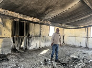 Suliman Mlihat, a herder living in Al Mu'arrajat East Bedouin community, in Jericho, standing in the community mosque set on fire by Israeli settlers on 2 February 2025. His tractor, used to transport water, was also burnt in the attack. Photo by OCHA.