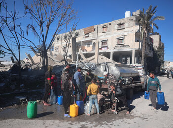 Children gather around water trucks in Rafah. Photo by UNICEF/El Baba