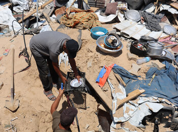 A Palestinian family trying to dig out what remains of their possessions after their house was destroyed in Bani Suheila, Khan Younis. Photo Themba Linden OCHA 