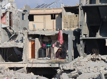 A Palestinian girl wiping the floor of a heavily damaged house in Abasan Al Kabira, area of Khan Younis. Photo by OCHA/Themba Linden, 7 September 2024