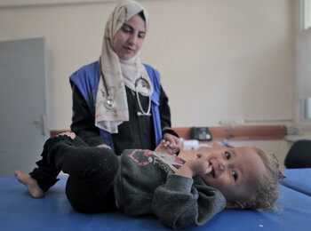 May 26, 2024, Rafah: A staff member from the UNRWA Health Team at the Tel Al-Sultan Health Center in Rafah area conducts a medical examination for a displaced child.© 2024 UNRWA Photo by Mohammed Hinnawi