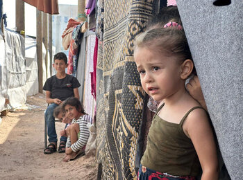 أطفال مهجرون يقيمون في مركز خانيونس للتدريب، الذي يعد أكثر مراكز الإيواء التابعة للأمم المتحدة اكتظاظًا في غزة. ويبقى العديد من المهجرين البالغ عددهم 22,000 مهجرًا في هذه المنشأة في الخارج، حيث لا يتوفر إلا أقل من مترين مربعين لكل واحد منهم. تصوير وكالة الأونروا.