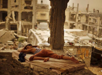 ילד פלסטיני ישן בתוך חורבות ביתו בשכונת שג׳אעייה שבעיר עזה, ספטמבר 2015. תצלום: סוהייב סאלם
