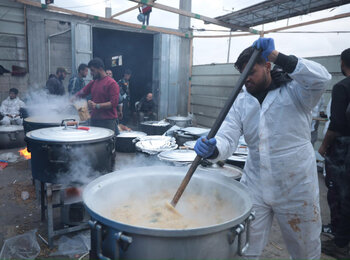 עובדים הומניטריים מכינים ארוחות אפטאר (סעודת שבירת צום הרמדאן,) חמות למשפחות עקורות בדרום עזה. מיזם זה, המיושם על ידי הארגונים ANERA ו-World Central Kitchen, הוא אחד מ-122 מיזמי סיוע  שהקרן ההומניטרית לשטח הפלסטיני הכבוש תומכת בהם עכשיו. צילום: ANERA