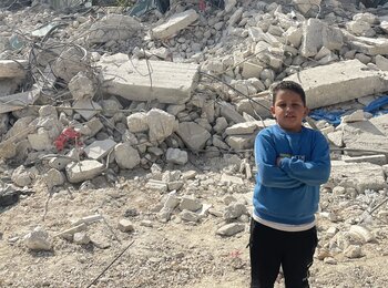 A Palestinian boy standing in front of his house that was under construction but was demolished by Israeli forces for lack of an Israeli-issued building permit, in Beit Ummar. Photo by OCHA, 14 November 2024. 