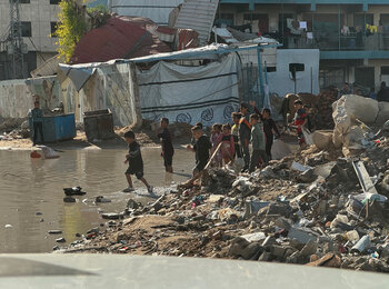 Children playing near a flooded area at a site for internally displaced people (IDPs) in Gaza city. Photo: OHCHR 