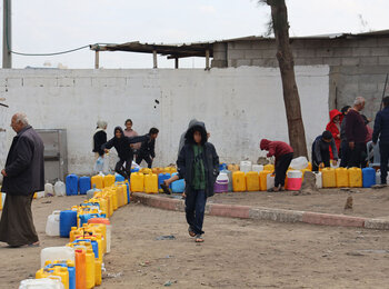 تجهيز الصفائح لتعبئتها بالمياه. لا يعمل سوى خط واحد من الخطوط الثلاثة التي تورد المياه من إسرائيل بسبب الأضرار التي لحقت بخط أنابيب في الآونة الأخيرة وهو في حاجة ماسة إلى التصليحات. وقد حذّرت اليونيسف من أن الأطفال في جنوب غزة لا يحصلون إلا على 1.5 إلى 2 لتر من الماء يوميًا، وهو أقل بكثير من المتطلبات الموصى بها للبقاء على قيد الحياة. تصوير اليونيسف/إياد البابا، 11 كانون الثاني/يناير 