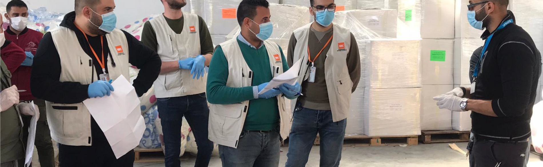 Staff of an aid organization preparing for the distribution of bedding sets to isolation centers. April 2020, Rafah. Photo by NRC