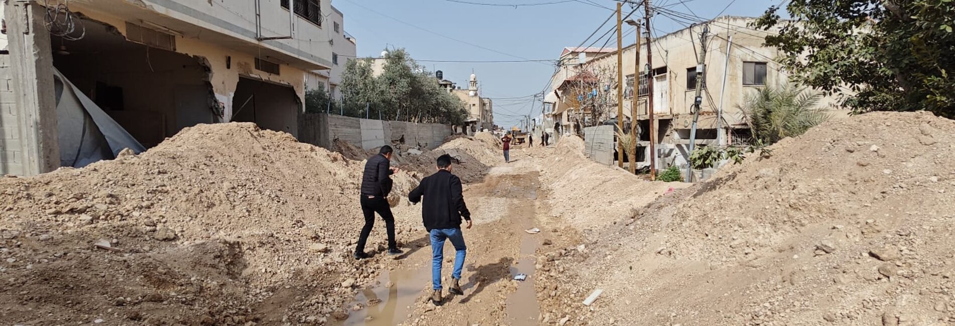 Palestinians make their way through the remains of a bulldozed road in Jenin city following an operation carried out by Israeli forces on 11 March 2025. Photo by Jenin municipality.    