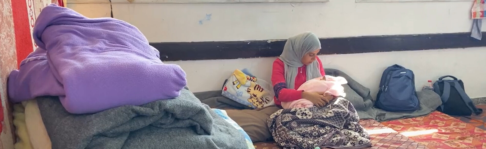 Palestinian mother and her newborn baby girl in a school used to shelter displaced people in the Gaza Strip. "There is no bathroom, no water, and no proper care,” she says. ”I have not checked or cleaned the caesarean section stitches yet.” Screenshot from a video by UNICEF