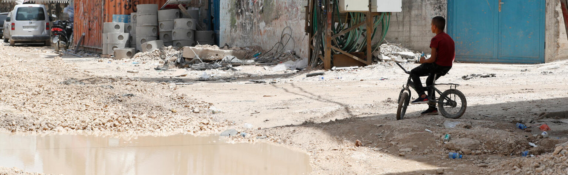 منطقة سكنية تعرضت فيها البنية التحتية لأضرار فادحة في مخيم جنين للاجئين في أعقاب عملية نفذتها القوات الإسرائيلية. تصوير اليونيسيف - دولة فلسطين/2024/علاء بدارنة، 25 أيار/مايو 2024