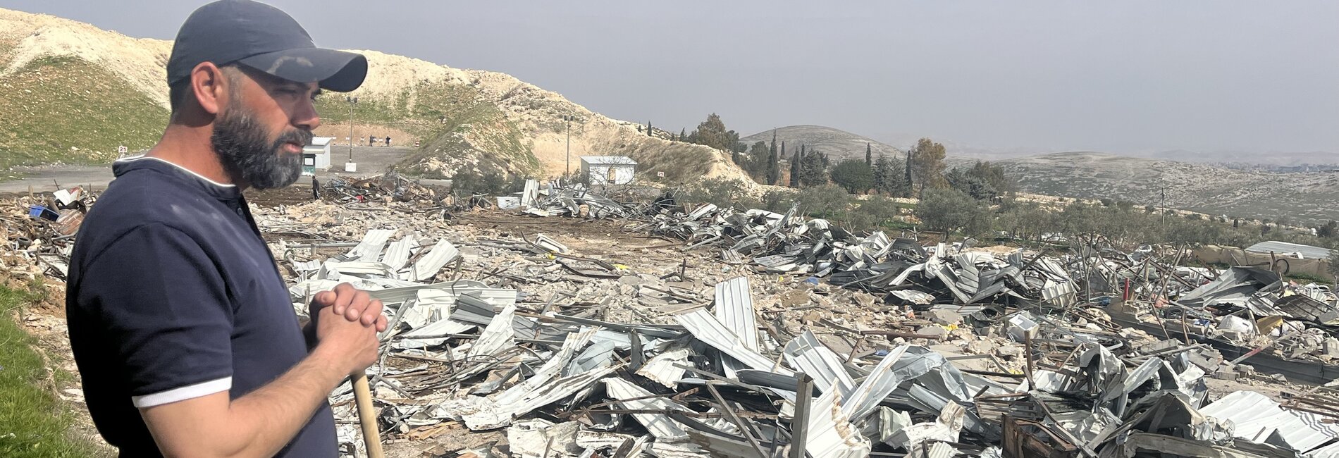 Palestinian observing his destroyed property following the demolition of 12 structures by Israeli forces in Az Za’ayyem Bedouin community, Jerusalem, on 3 March 2025. Photo by OCHA