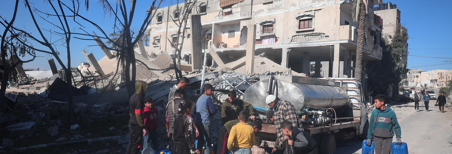 Children gather around water trucks in Rafah. Photo by UNICEF/El Baba