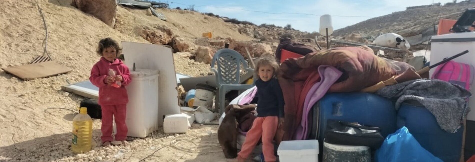 Children amid properties extracted from a Palestinian house set to be demolished by Israeli forces in Tell al Khashaba, Nablus. Photo by OCHA, 10 December 2024 