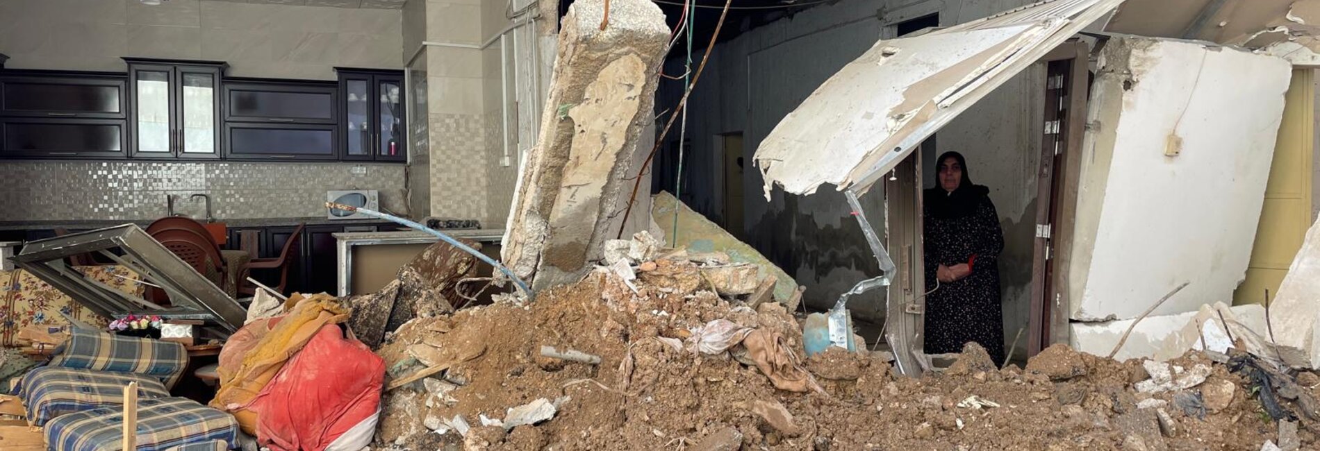 An elderly woman stands amid the ruins of her home, destroyed during a 46-hour Israeli operation in the Jenin refugee camp that began on 18 November 2024. Photo: OCHA. 