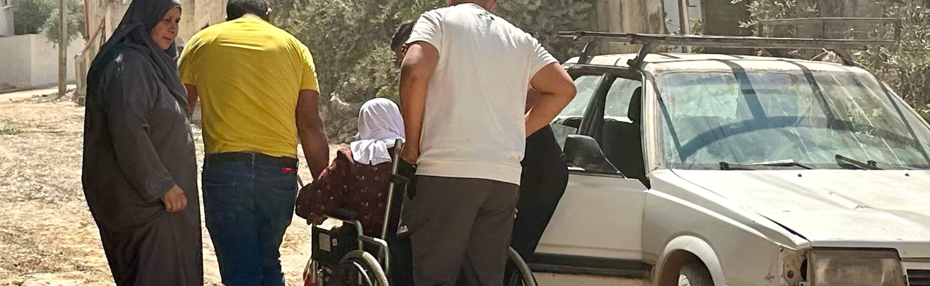 An elderly Palestinian woman in a wheelchair navigates a destroyed street in Jenin on her way to a hospital, following a ten-day operation by Israeli forces. Photo by OCHA, 8 September 2024 