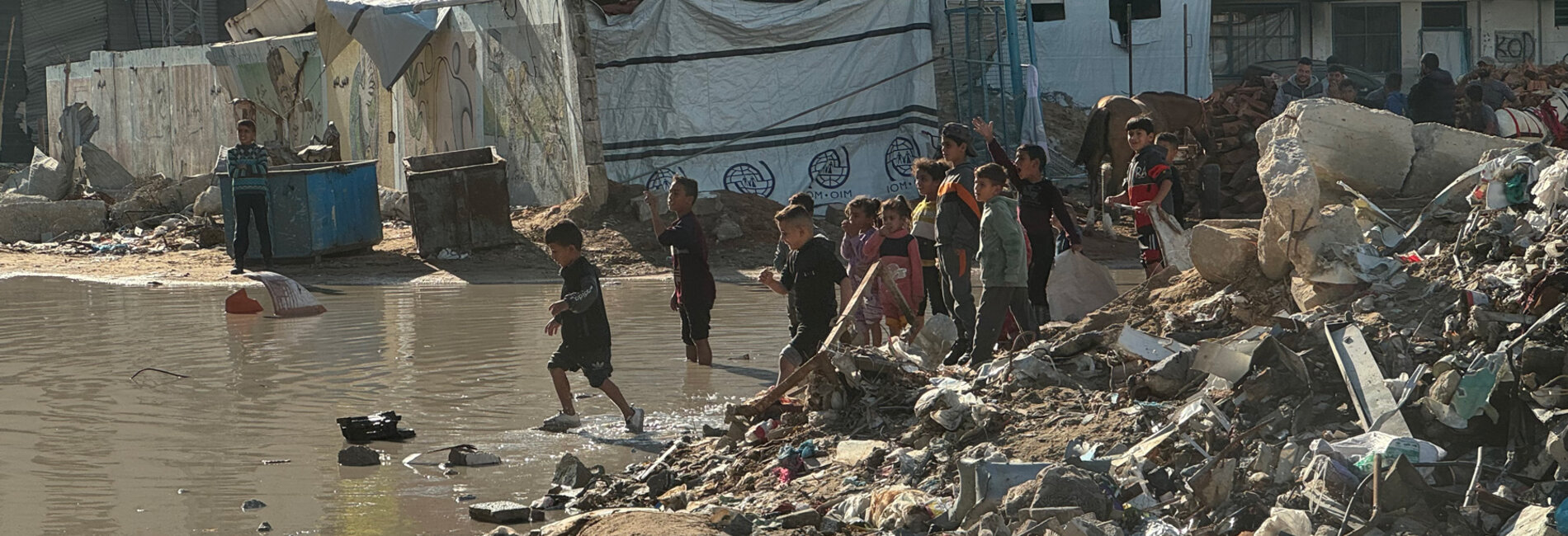 Children playing near a flooded area at a site for internally displaced people (IDPs) in Gaza city. Photo: OHCHR 