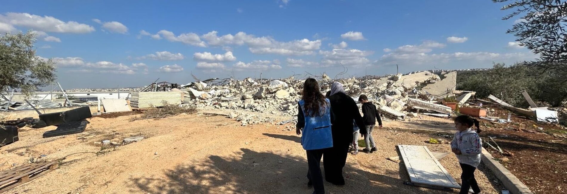 A Palestinian family from Deir Ballut, Salfit, shows an aid worker the three agricultural structures demolished by the Israeli Civil Administration, 17 December 2024. Photo by OCHA