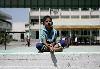 IDP child at WFP food distribution in UNRWA collective shelter, Rafah, August 2014. Photo by WFP/Eyad al Baba